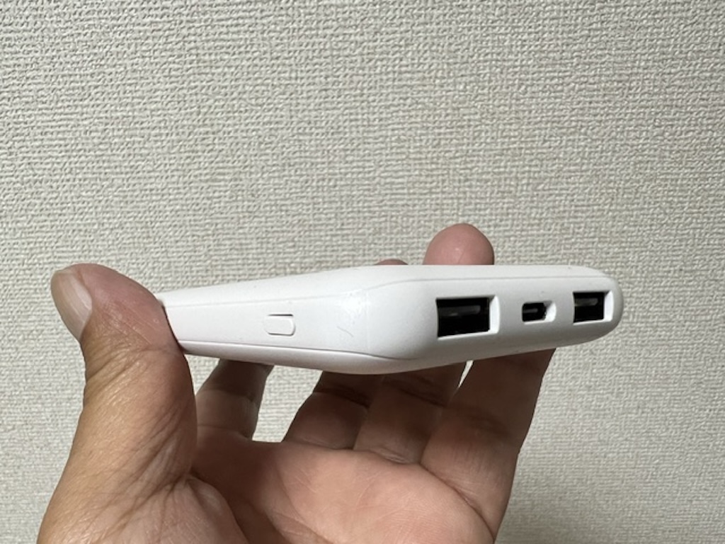 エレコム モバイルバッテリー DE-C66-10000WHの側面アングル。持ちやすい薄型フォルムとポート・ボタンの配置