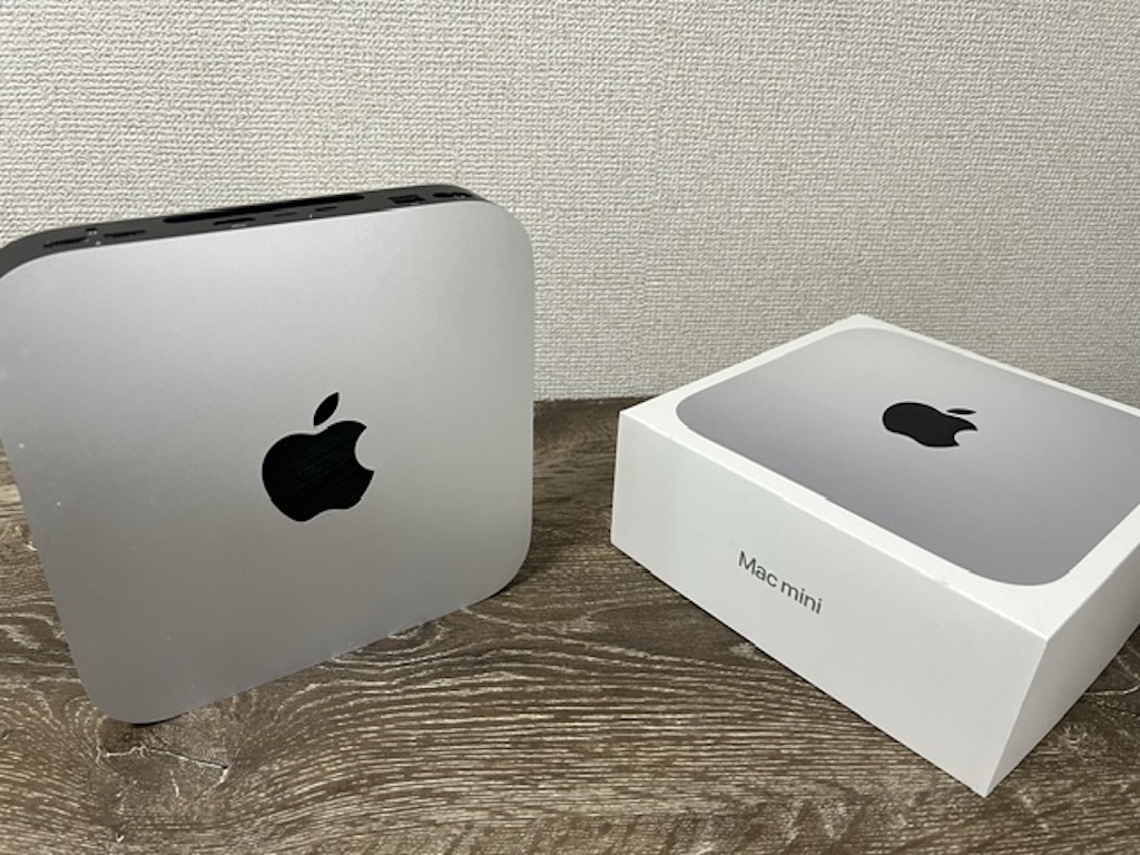 Mac mini(M1チップ搭載)の本体と購入時の白い外箱が並んでいる様子