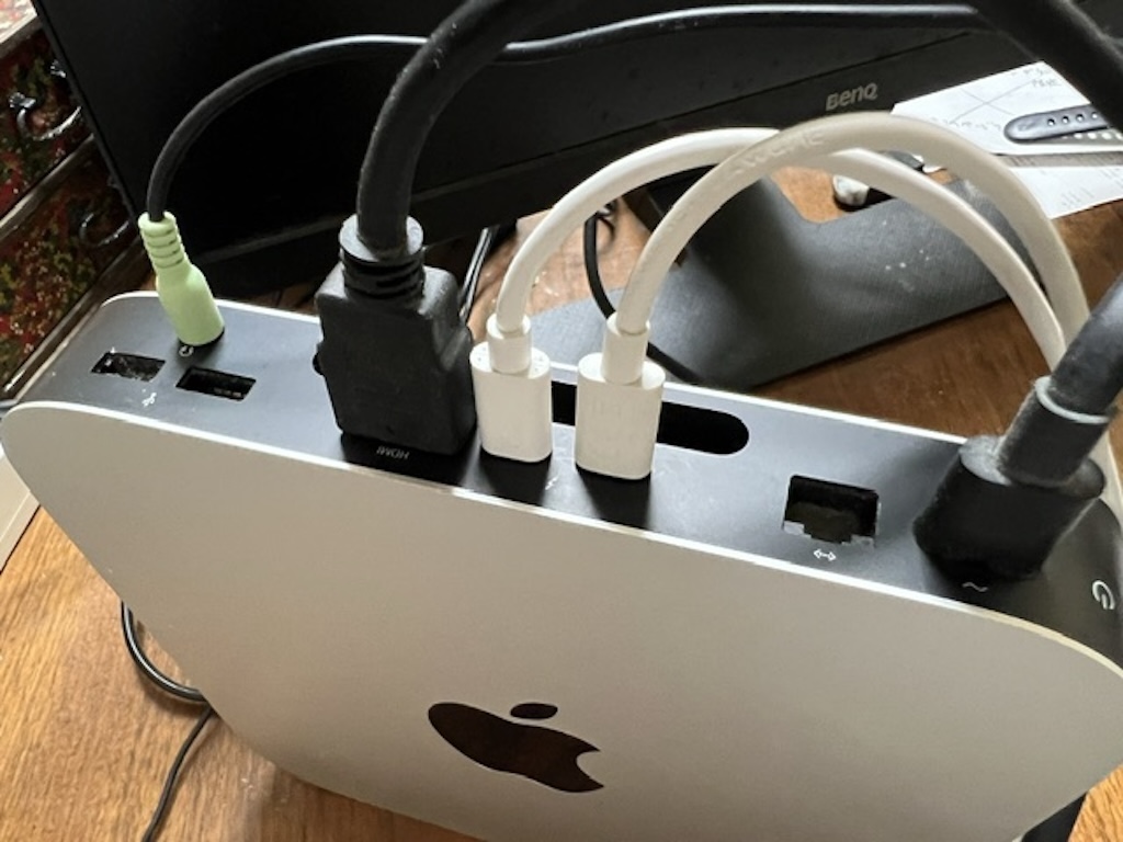 電源ケーブルなどが背面ポートに接続されているMac mini（M1）の使用中の様子